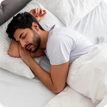 Asleep young man sleeping, resting peacefully in comfortable bed, lying with closed eyes.